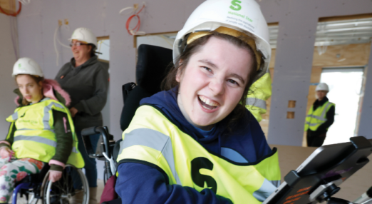 Shannon smiling at the new student accommodation build