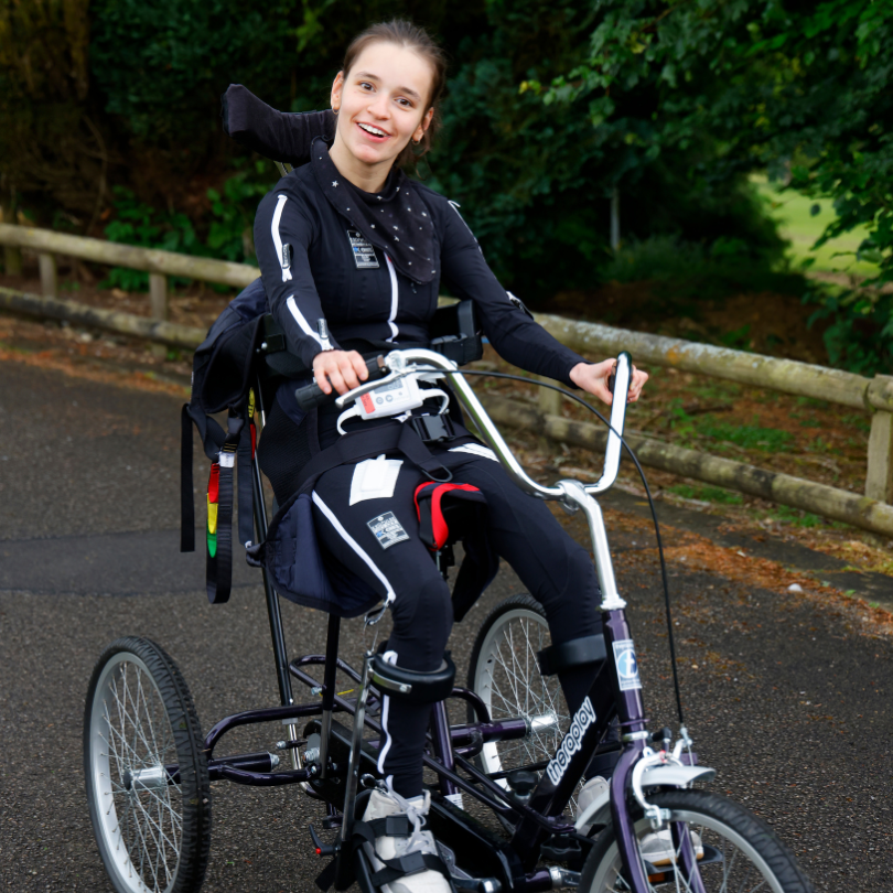 Ella smiling and wearing Mollii suit on trike