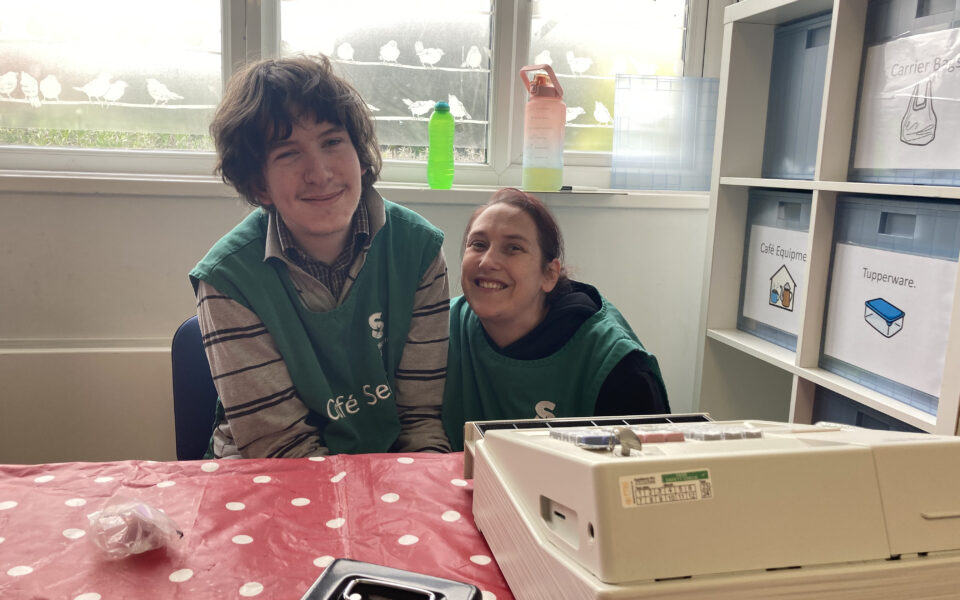 Male student and female staff member smiling at Cafe Seren