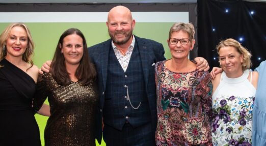 Smiling staff on stage at long service awards